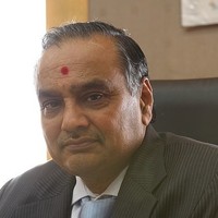 Archival portrait of Rajnikant S. Ajmera seated at his office desk